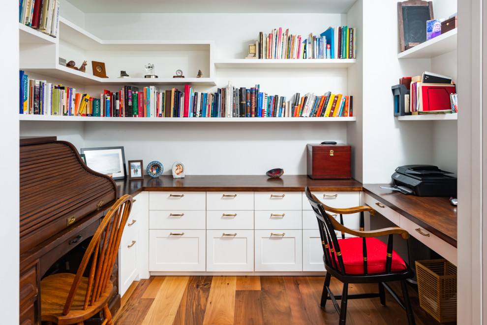 Idéer för vintage arbetsrum, med vita väggar, mellanmörkt trägolv, ett inbyggt skrivbord och brunt golv