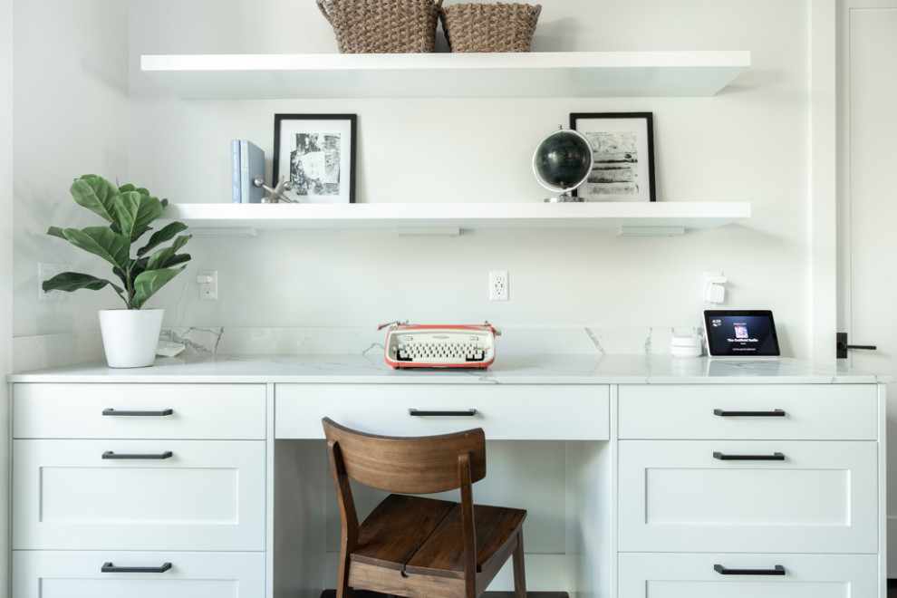 Idéer för små amerikanska arbetsrum, med vita väggar, mellanmörkt trägolv, ett inbyggt skrivbord och flerfärgat golv