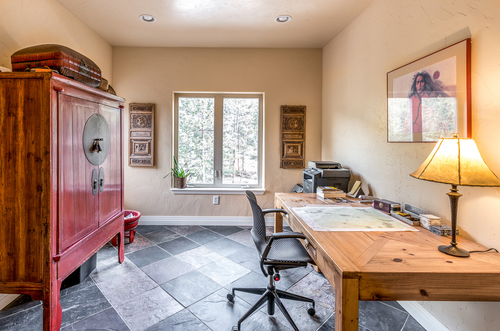 Small eclectic home office in Denver with beige walls and a freestanding desk.