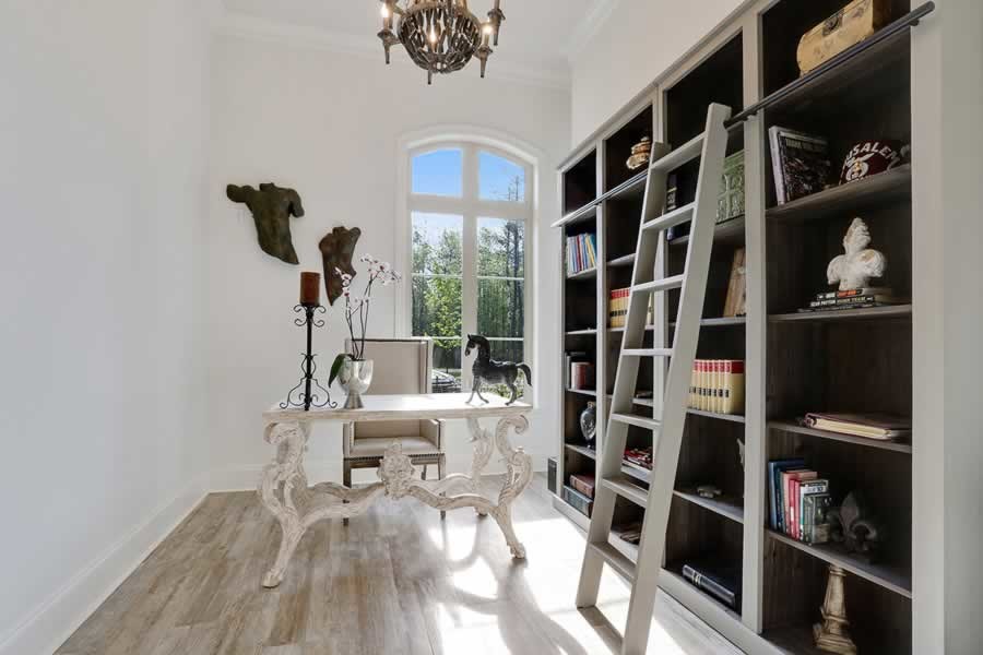 This is an example of a medium sized contemporary home office in New Orleans with white walls, light hardwood flooring, no fireplace, a freestanding desk and brown floors.
