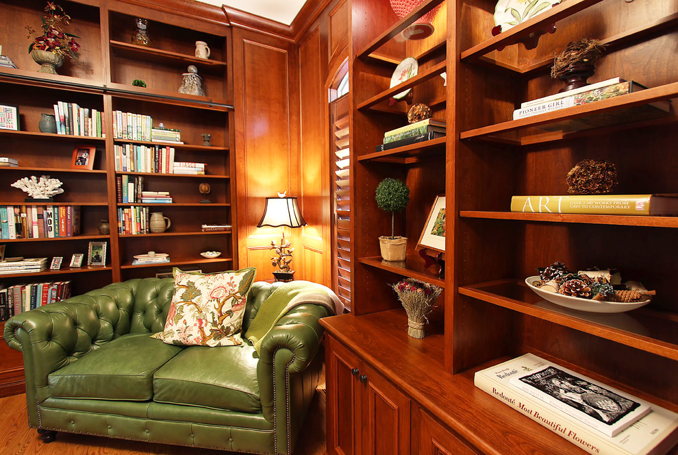 Ejemplo de despacho clásico de tamaño medio con biblioteca, suelo de madera en tonos medios y escritorio independiente
