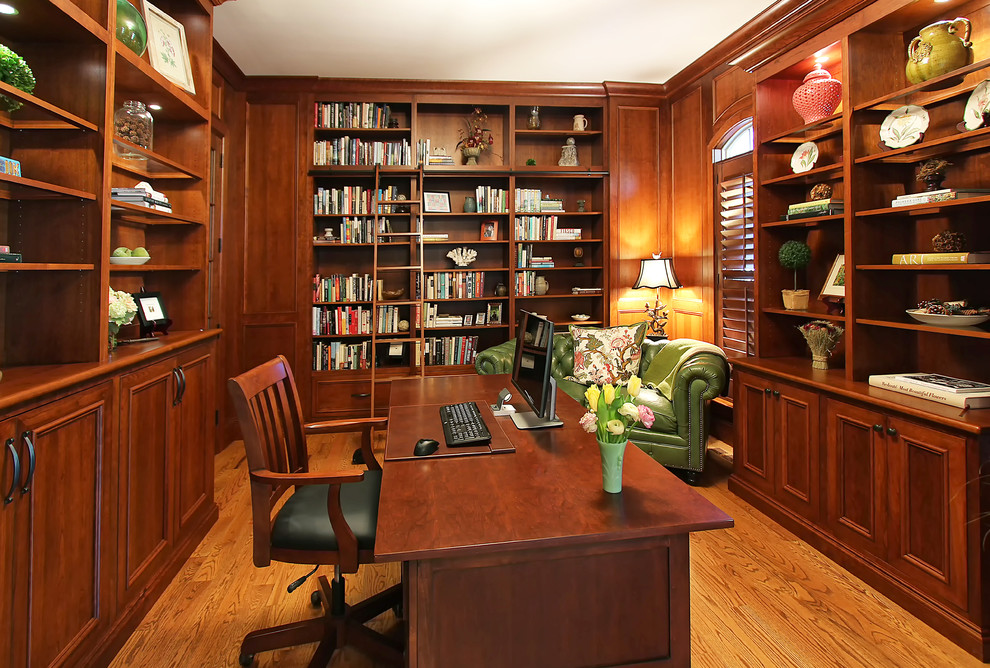 Пример оригинального дизайна: домашняя библиотека среднего размера в классическом стиле с паркетным полом среднего тона и отдельно стоящим рабочим столом