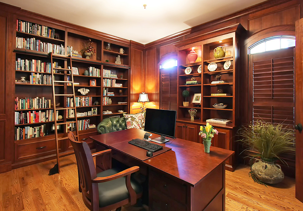 Inspiration för mellanstora klassiska arbetsrum, med ett bibliotek, mellanmörkt trägolv och ett fristående skrivbord