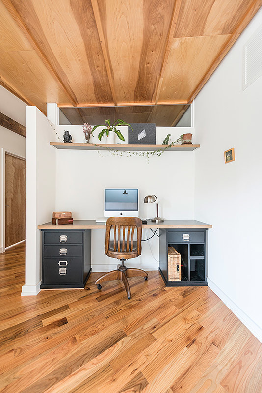 Imagen de despacho urbano de tamaño medio sin chimenea con paredes blancas, suelo de madera clara y escritorio independiente
