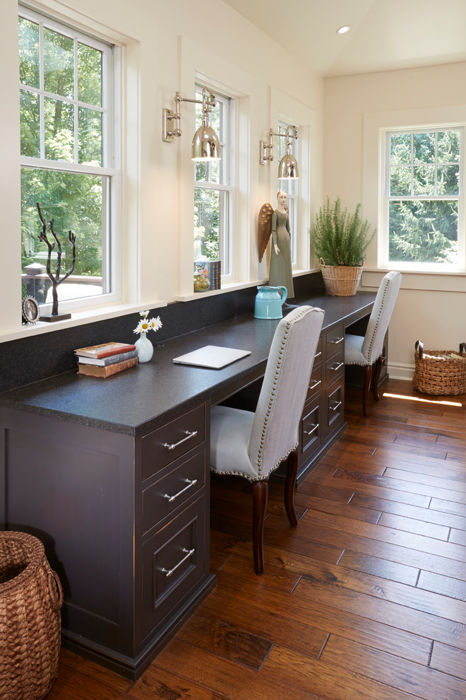 Mittelgroßes Eklektisches Arbeitszimmer mit beiger Wandfarbe, braunem Holzboden und Einbau-Schreibtisch in Sonstige