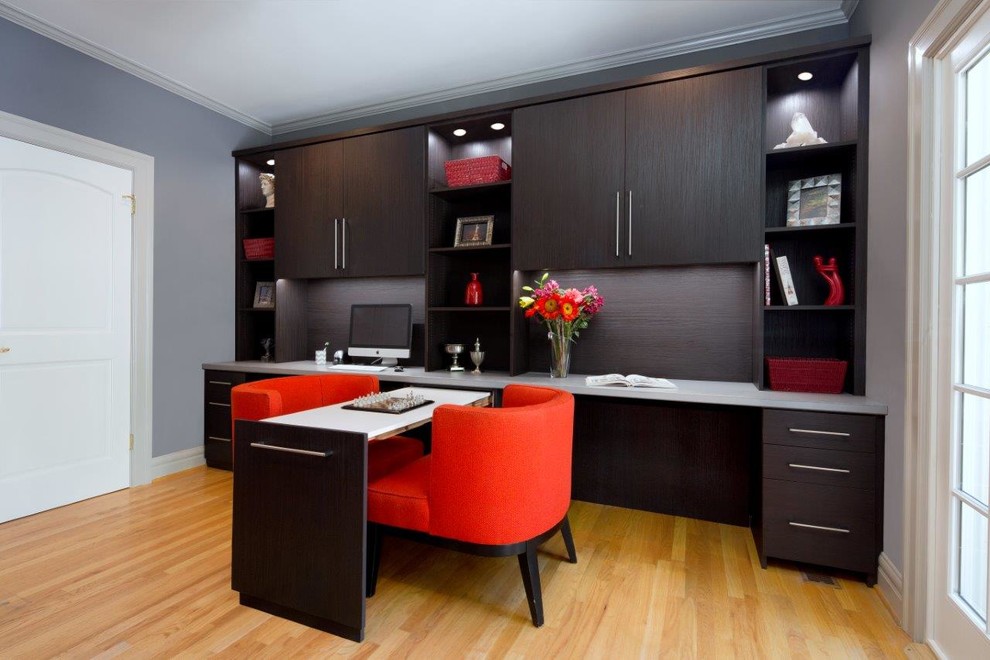 Diseño de despacho contemporáneo de tamaño medio sin chimenea con suelo de madera en tonos medios, escritorio empotrado y paredes grises