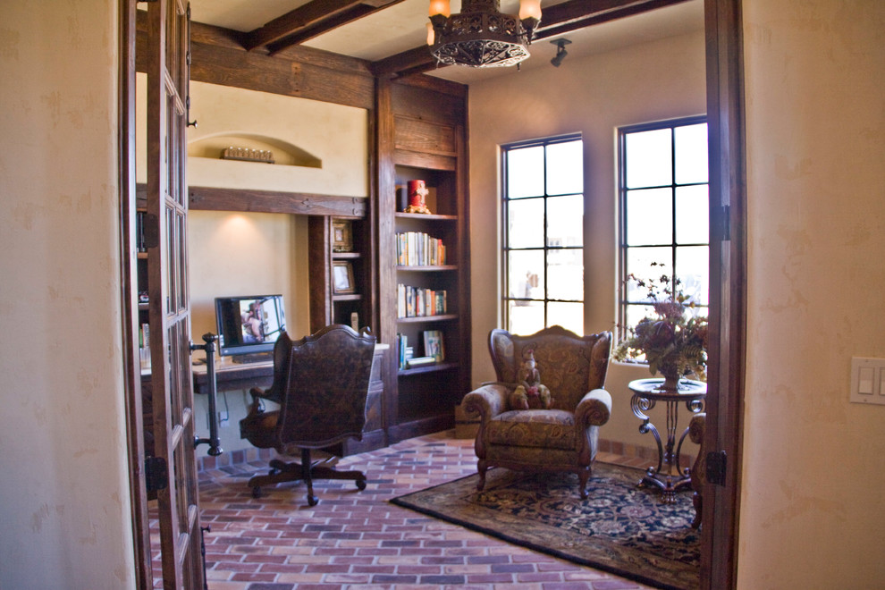 オースティンにあるラスティックスタイルのおしゃれな書斎 (レンガの床、造り付け机) の写真