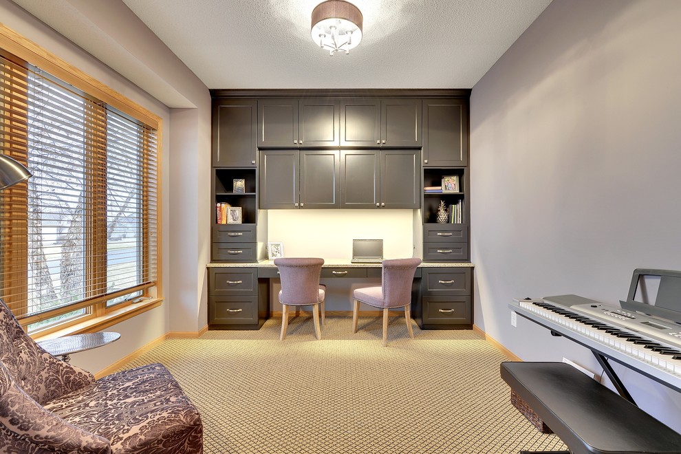 This is an example of a classic home office in Minneapolis with carpet, a built-in desk and grey walls.
