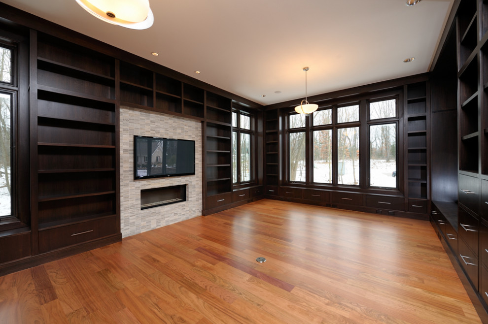 Aménagement d'un grand bureau moderne en bois avec une bibliothèque ou un coin lecture, un mur marron, un sol en bois brun, une cheminée standard, un manteau de cheminée en pierre et un bureau indépendant.