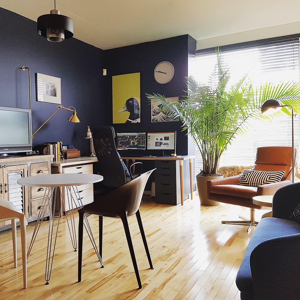 Imagen de estudio vintage de tamaño medio sin chimenea con paredes azules, suelo de madera clara, escritorio independiente y suelo beige