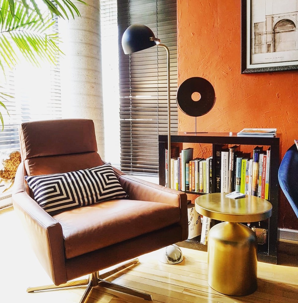 Bild på ett mellanstort retro hemmastudio, med orange väggar, ljust trägolv, ett fristående skrivbord och beiget golv