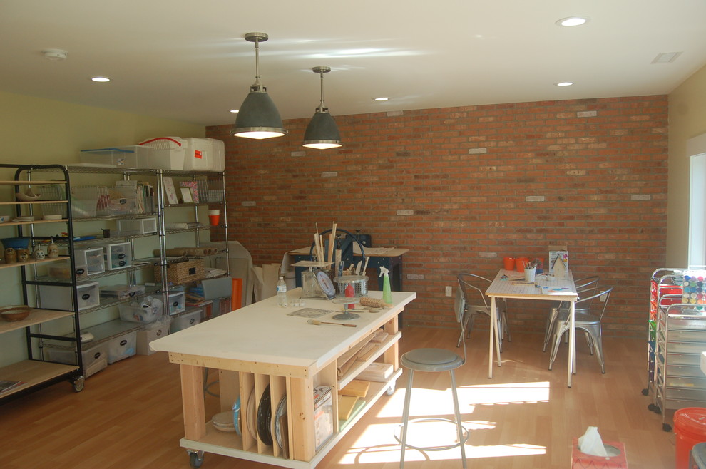 Foto på ett mellanstort funkis hobbyrum, med ett fristående skrivbord, gula väggar och mellanmörkt trägolv