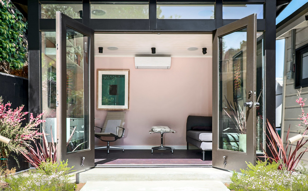Immagine di un piccolo atelier moderno con pareti rosa, pavimento in vinile, scrivania incassata e pavimento marrone