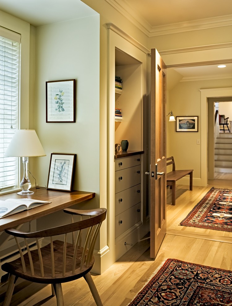 Klassisches Arbeitszimmer mit beiger Wandfarbe, braunem Holzboden und Einbau-Schreibtisch in Burlington