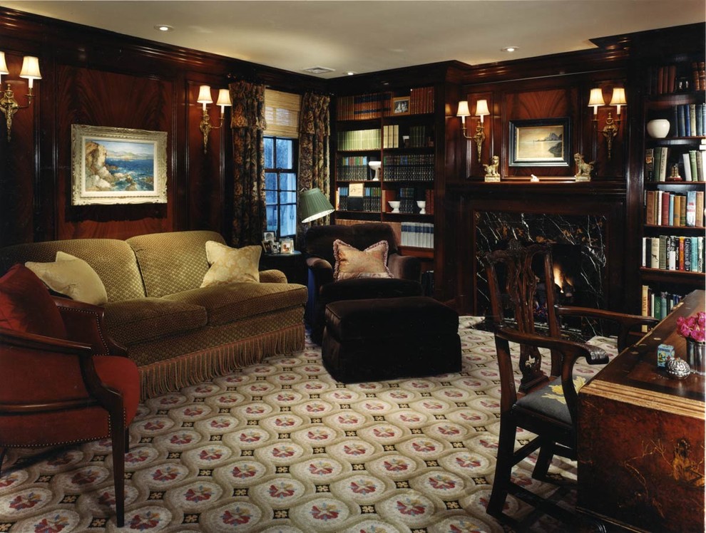 Mittelgroßes Klassisches Lesezimmer mit Kamin, brauner Wandfarbe, Teppichboden, Kaminumrandung aus Holz, freistehendem Schreibtisch und buntem Boden in Birmingham