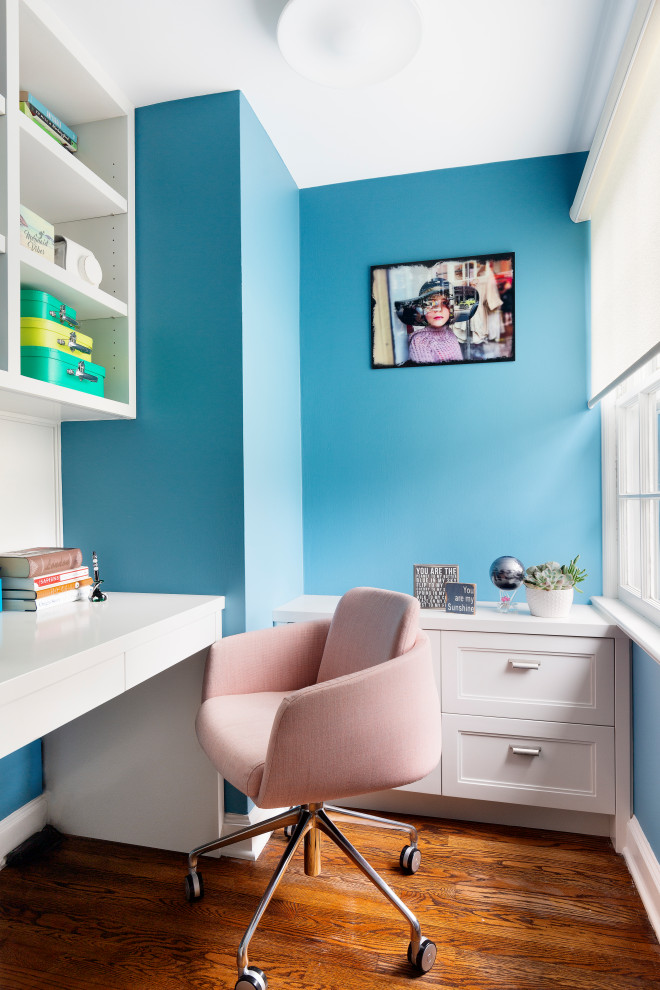 Idée de décoration pour un bureau design avec un mur bleu, parquet foncé, un bureau intégré et un sol marron.