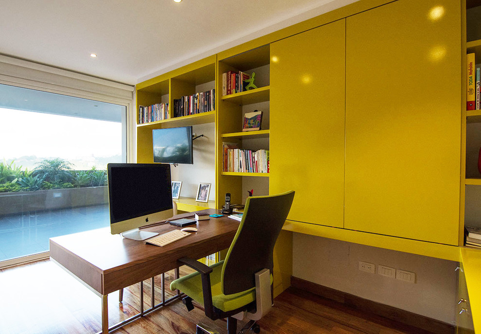 Photo of a contemporary home office in Miami with beige walls, light hardwood flooring and a freestanding desk.