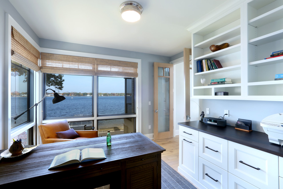 Источник вдохновения для домашнего уюта: огромное рабочее место в морском стиле с серыми стенами, светлым паркетным полом и отдельно стоящим рабочим столом без камина