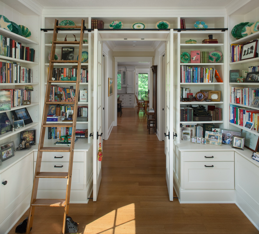 Inspiration för mycket stora klassiska arbetsrum, med vita väggar, mellanmörkt trägolv, ett bibliotek och brunt golv