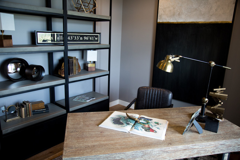 Mittelgroßes Klassisches Arbeitszimmer mit Arbeitsplatz, grauer Wandfarbe, hellem Holzboden, freistehendem Schreibtisch und braunem Boden in Sonstige