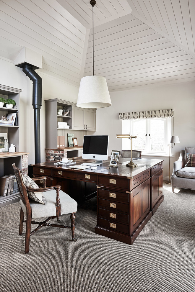 Diseño de despacho clásico con paredes blancas, moqueta, estufa de leña y escritorio independiente