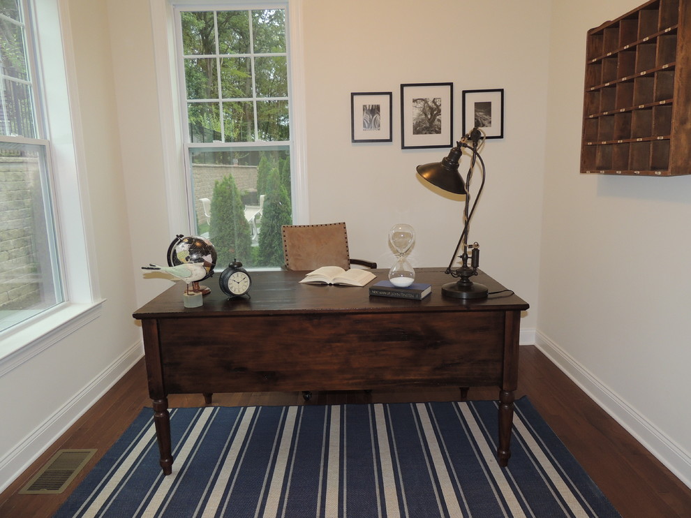 Ejemplo de despacho costero de tamaño medio sin chimenea con paredes beige, suelo vinílico, escritorio independiente y suelo marrón