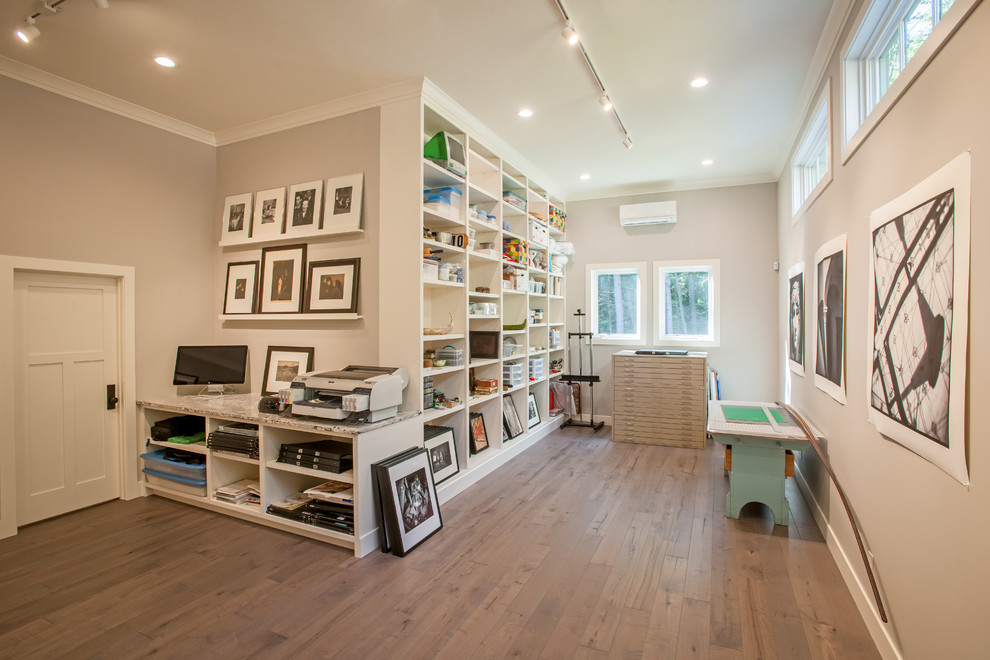 Imagen de sala de manualidades campestre de tamaño medio con paredes grises, suelo de madera en tonos medios y suelo gris