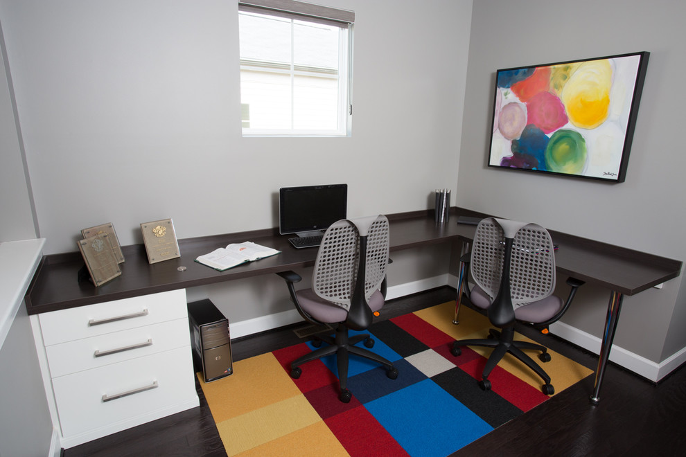 Diseño de despacho contemporáneo de tamaño medio con paredes grises, suelo de madera oscura y escritorio empotrado