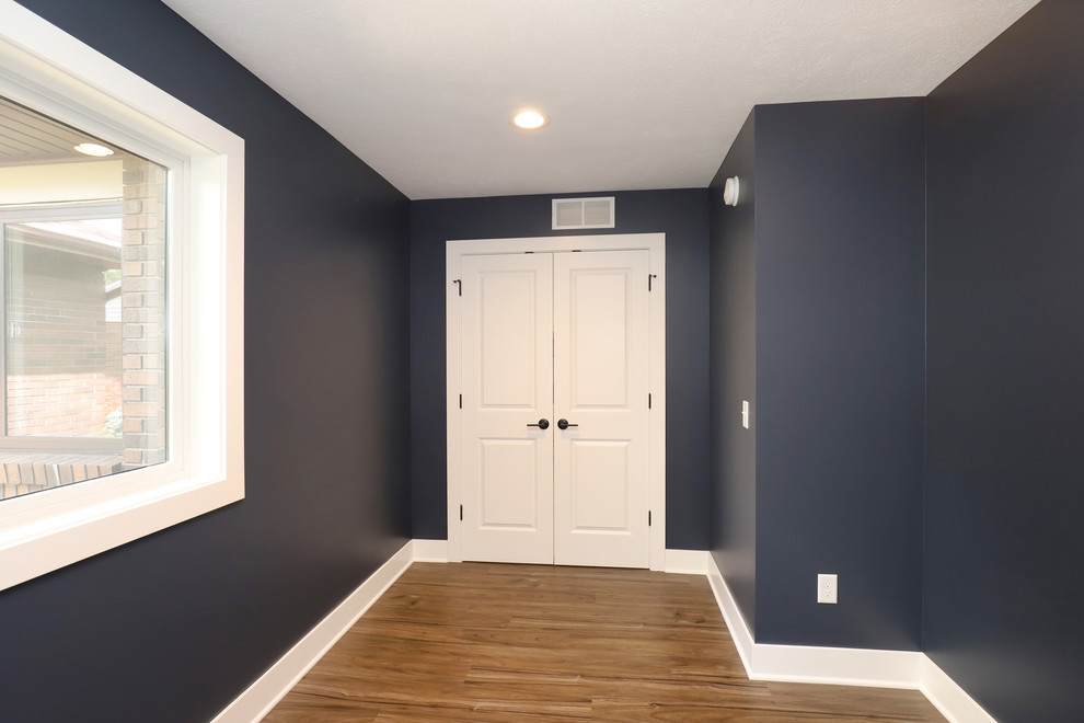 Cette image montre un petit bureau traditionnel avec un mur bleu, sol en stratifié et un sol marron.