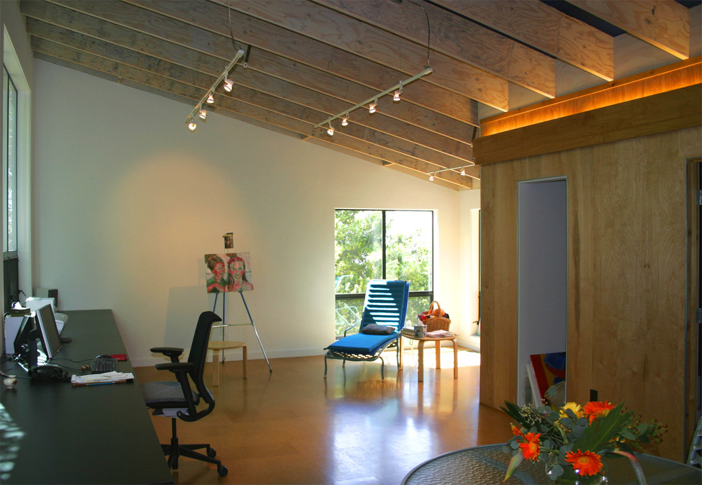 На фото: маленькое рабочее место в стиле модернизм с белыми стенами, пробковым полом и встроенным рабочим столом для на участке и в саду с