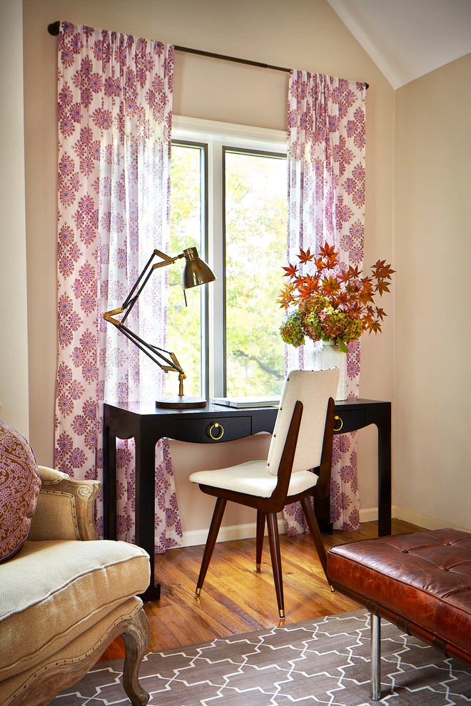 Classic study in New York with beige walls, medium hardwood flooring and a freestanding desk.