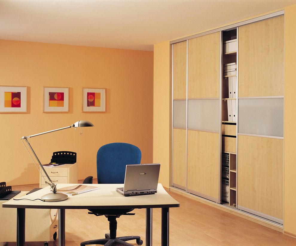 Exempel på ett mellanstort modernt arbetsrum, med gula väggar, ljust trägolv och ett fristående skrivbord