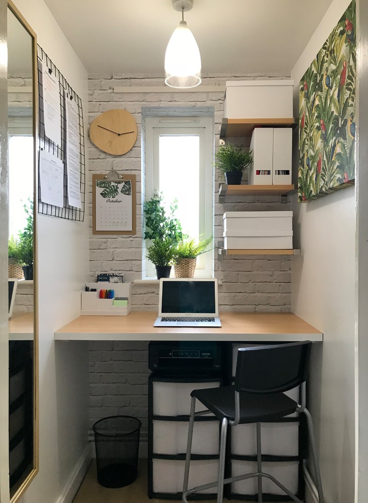 Idee per un ufficio design con pareti bianche, parquet chiaro, scrivania incassata e pavimento beige