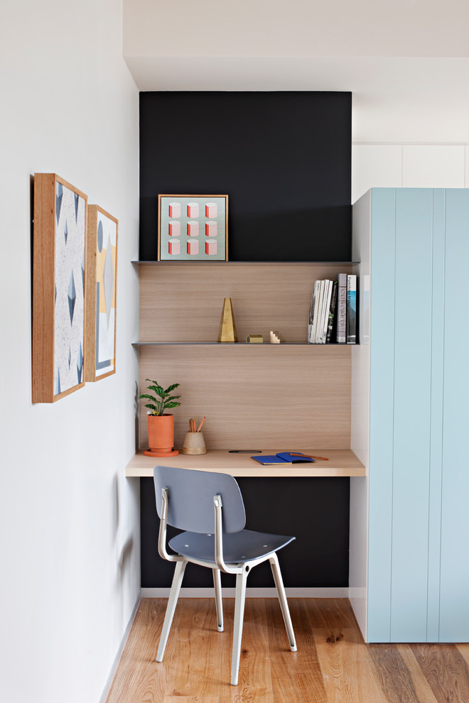 Photo of a small modern study in Melbourne with black walls and a built-in desk.