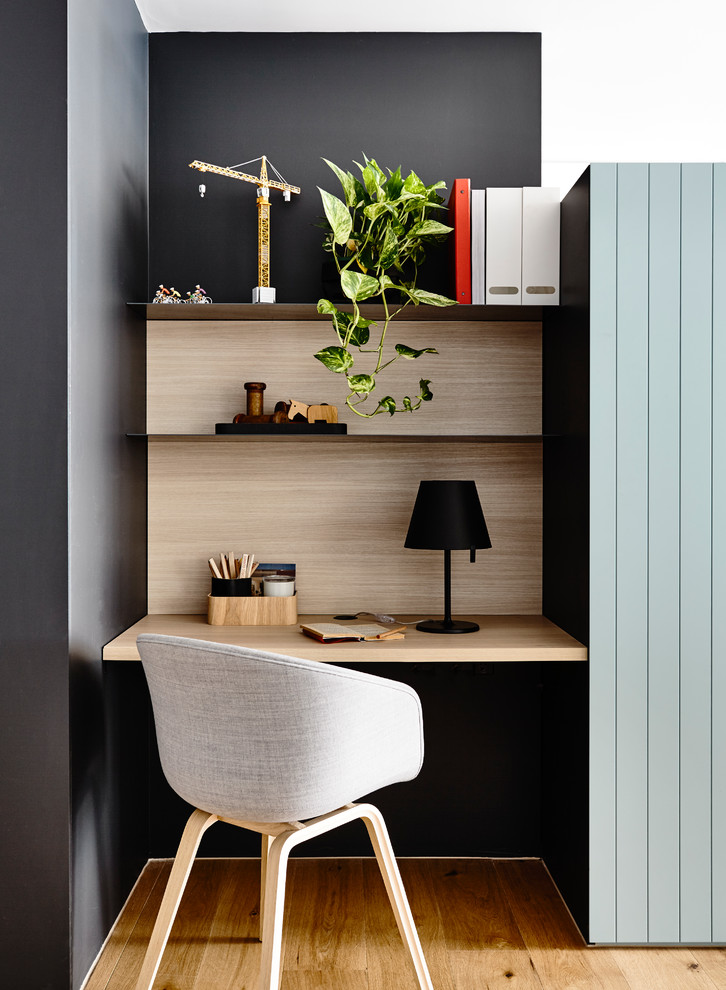 Inspiration for a small modern built-in desk study room remodel in Melbourne with black walls
