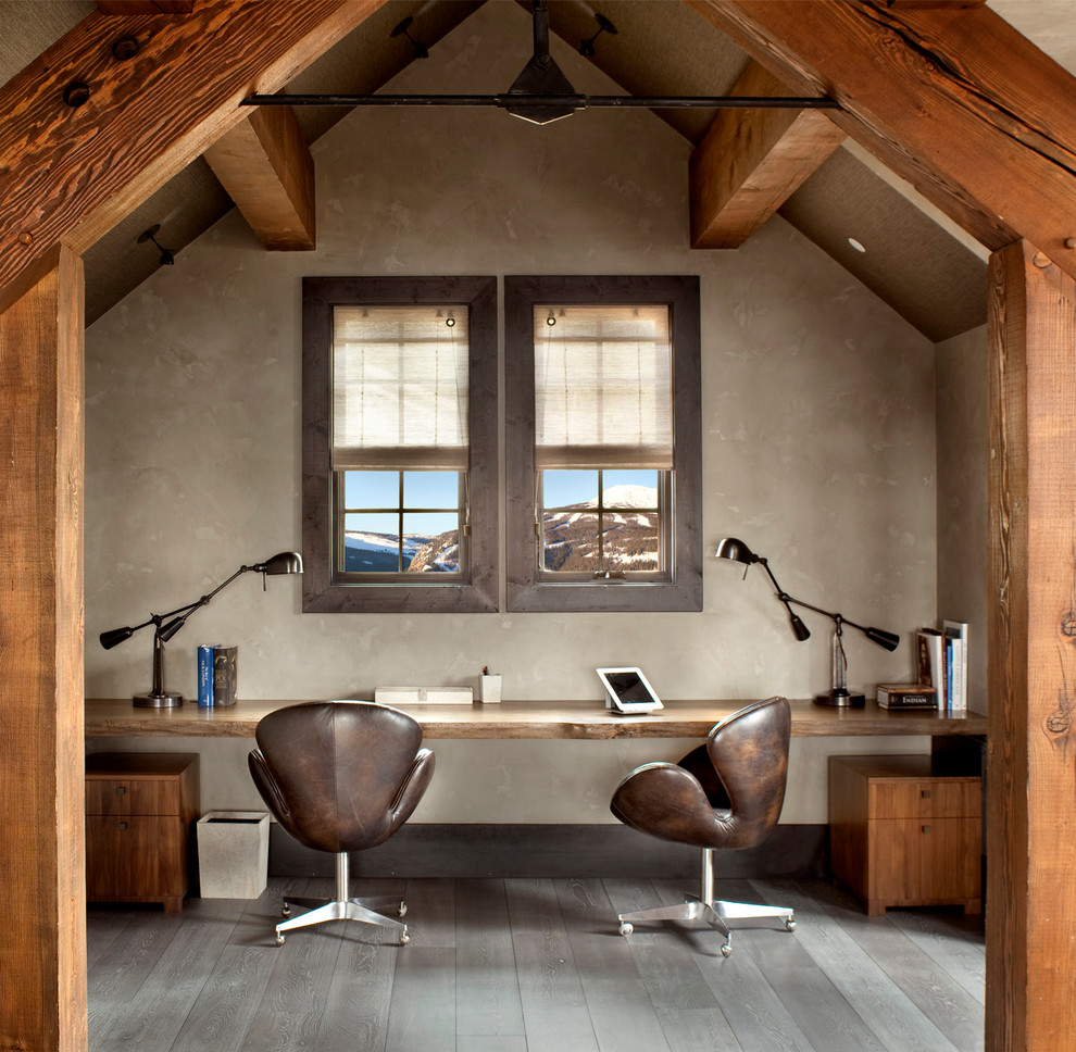 На фото: кабинет в стиле рустика с темным паркетным полом, встроенным рабочим столом и серыми стенами без камина