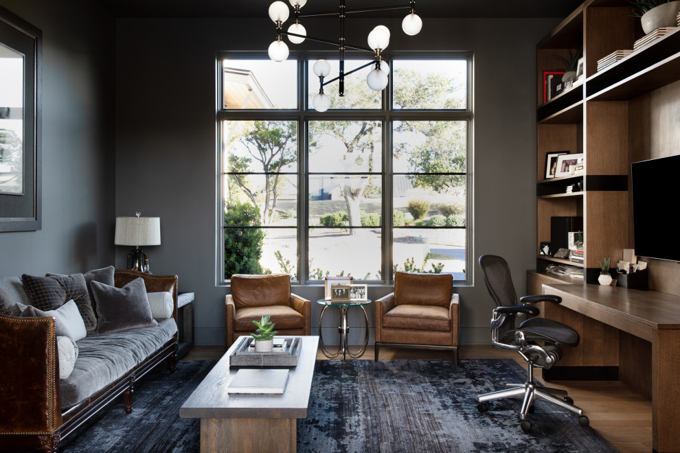 オースティンにあるラグジュアリーな広いトランジショナルスタイルのおしゃれなホームオフィス・書斎 (ライブラリー、グレーの壁、淡色無垢フローリング、暖炉なし、造り付け机、茶色い床) の写真