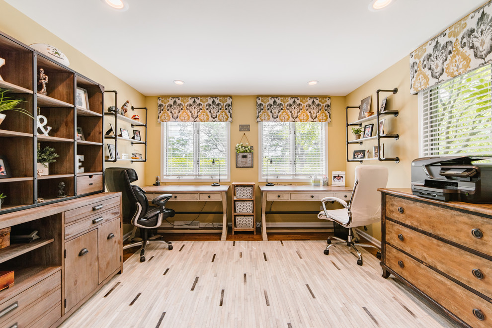 Esempio di uno studio industriale di medie dimensioni con pareti beige, pavimento in legno massello medio, scrivania autoportante e pavimento marrone