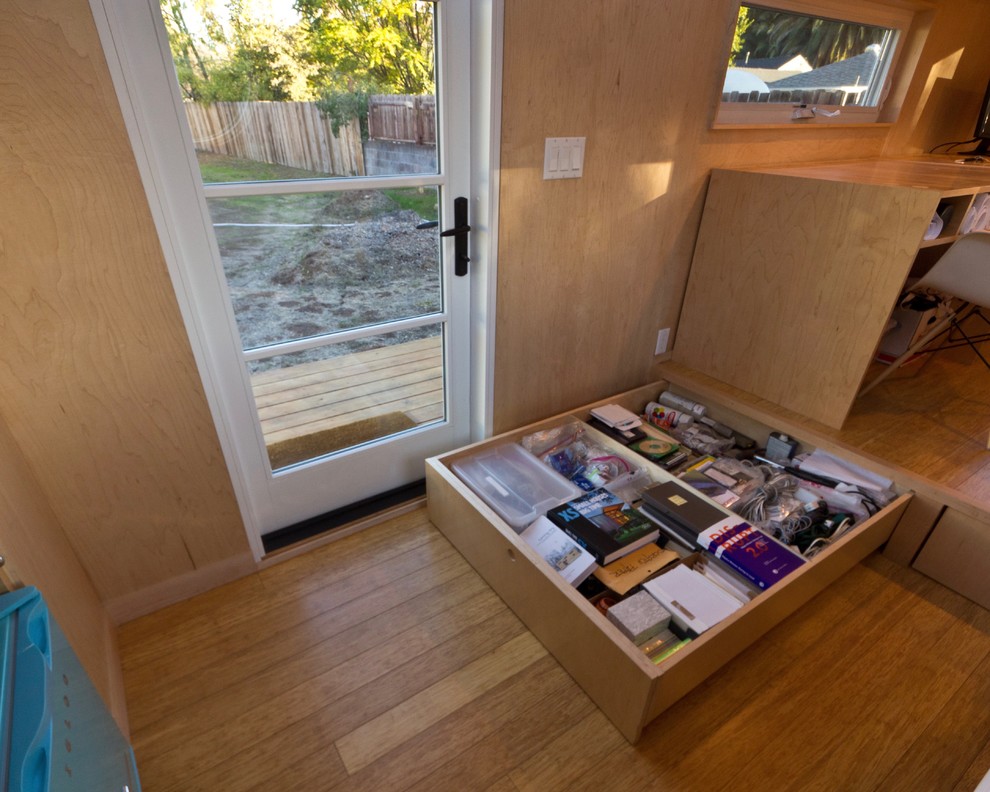 Imagen de estudio minimalista pequeño con paredes blancas, suelo de bambú y escritorio independiente