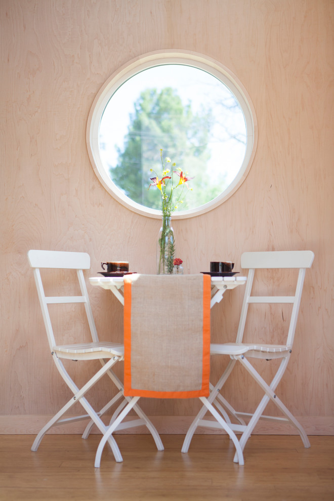 Inspiration för en liten funkis matplats med öppen planlösning, med ljust trägolv och vita väggar