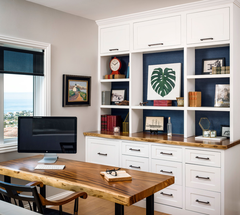 Foto de despacho costero de tamaño medio con paredes beige, suelo de madera clara, escritorio independiente y suelo beige