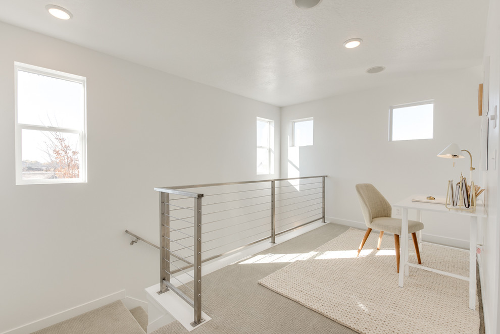 Idéer för små funkis hemmabibliotek, med vita väggar, heltäckningsmatta, ett fristående skrivbord och grått golv