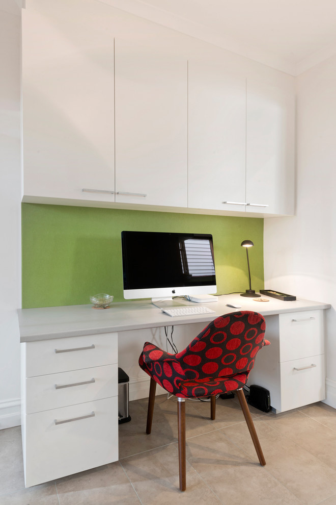 Immagine di un piccolo studio design con pareti verdi e scrivania incassata