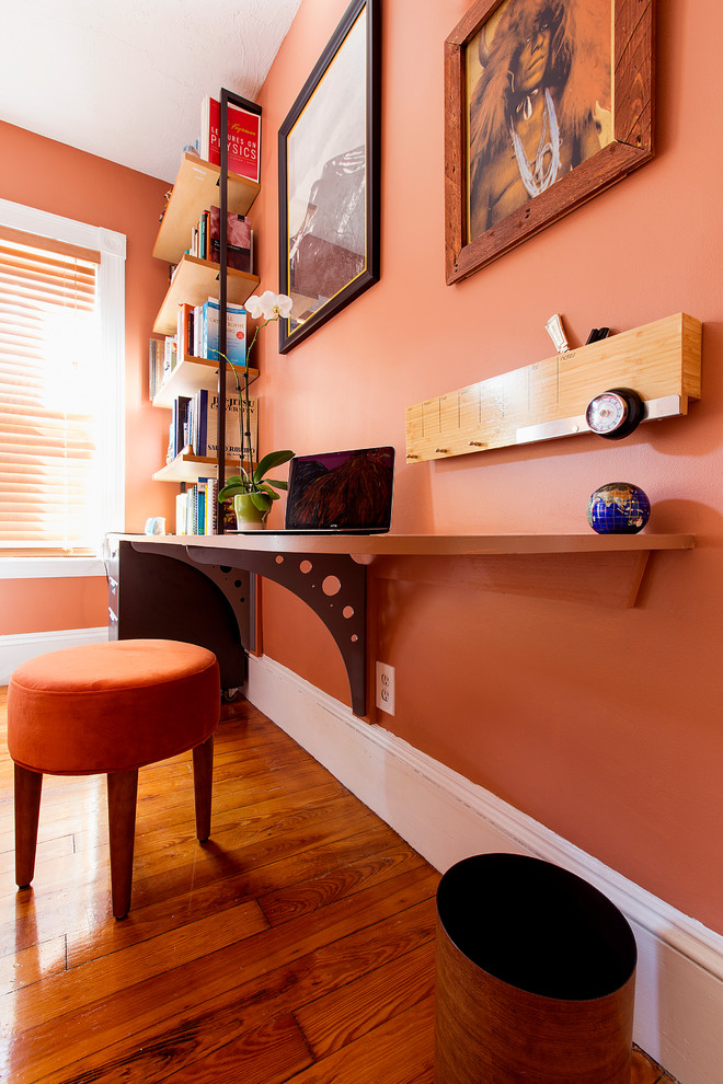 Diseño de despacho clásico renovado pequeño sin chimenea con parades naranjas, suelo de madera en tonos medios, escritorio empotrado y suelo marrón