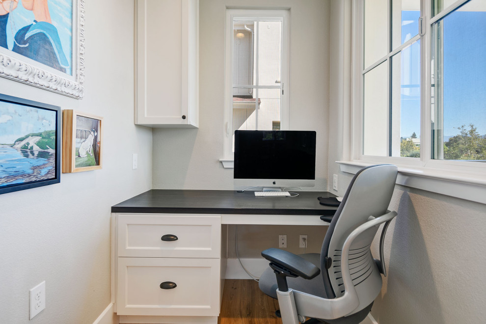 Idées déco pour un petit bureau classique avec un mur gris, parquet clair, aucune cheminée et un bureau intégré.
