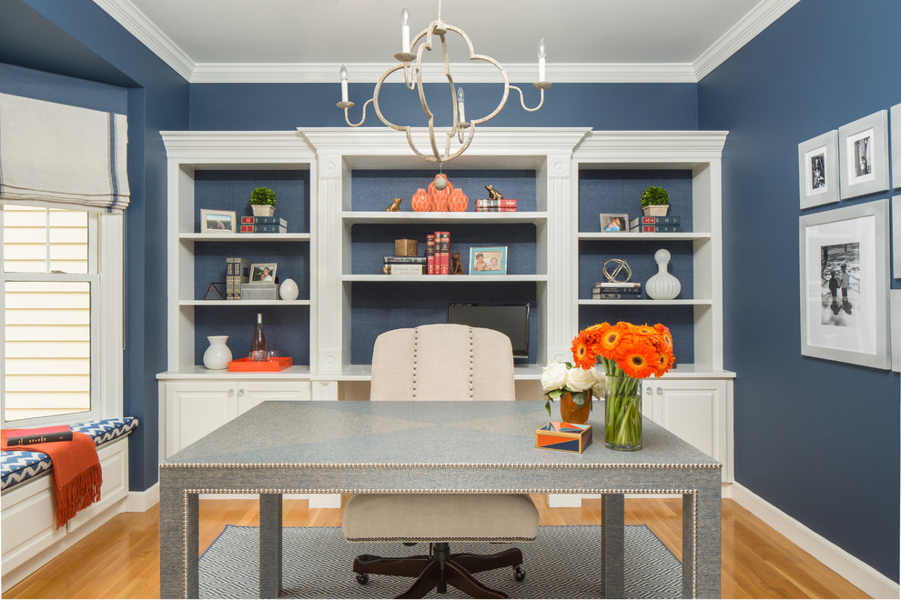 Diseño de despacho clásico renovado de tamaño medio con paredes azules, suelo de madera clara y escritorio independiente