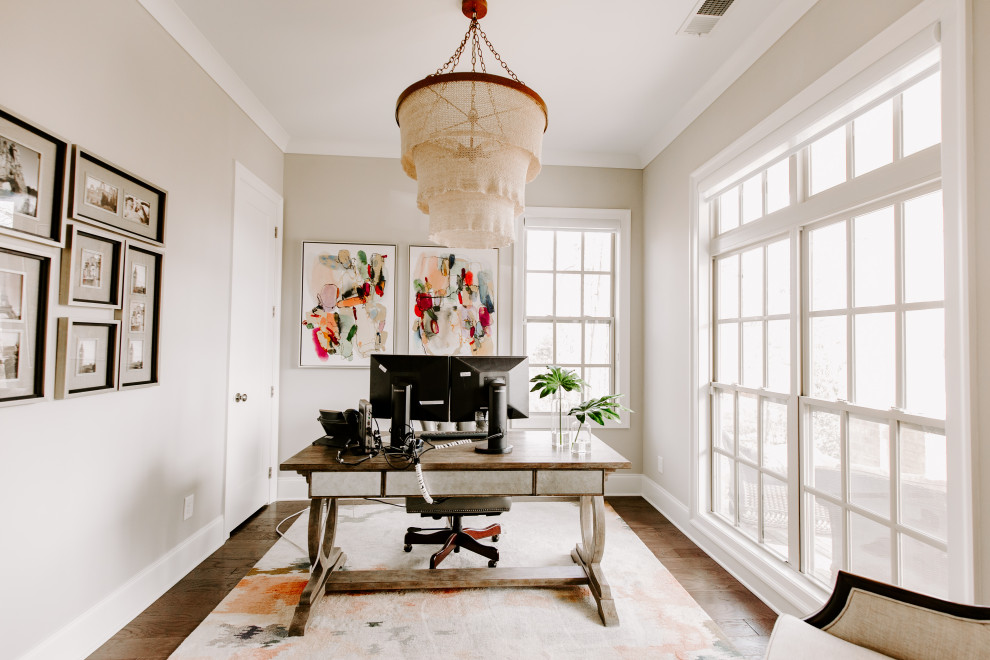 アトランタにある高級な小さなトランジショナルスタイルのおしゃれな書斎 (ベージュの壁、濃色無垢フローリング、自立型机、茶色い床) の写真