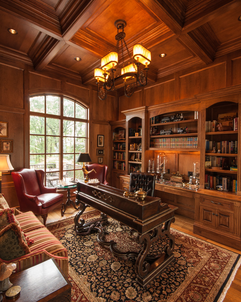 Foto de despacho clásico grande con suelo de madera en tonos medios y escritorio independiente