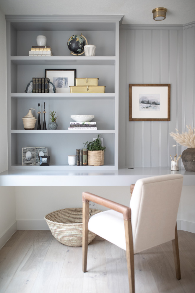 Diseño de despacho clásico renovado de tamaño medio con paredes grises, suelo de madera clara, escritorio empotrado y suelo beige