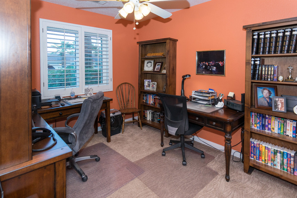 Idee per un ufficio classico di medie dimensioni con pareti arancioni, moquette, nessun camino e scrivania autoportante